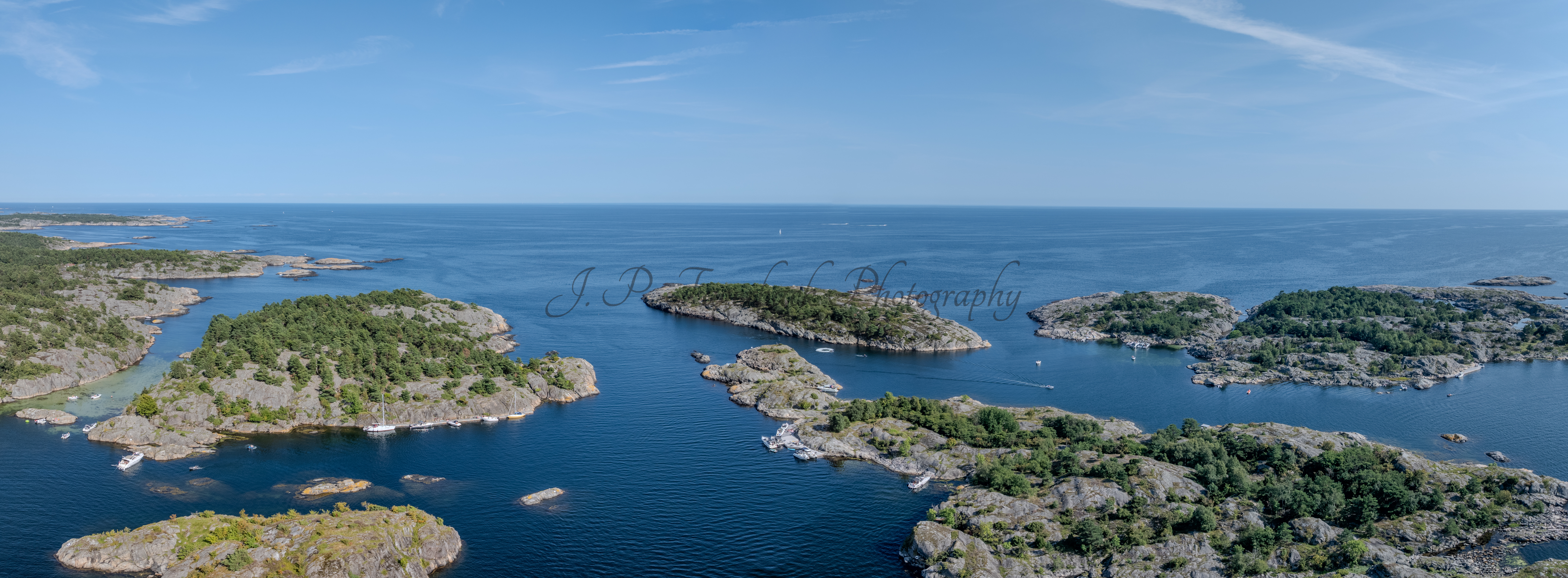 Islands with green vegitaions in sourounded by blue ocean water under a blue sky