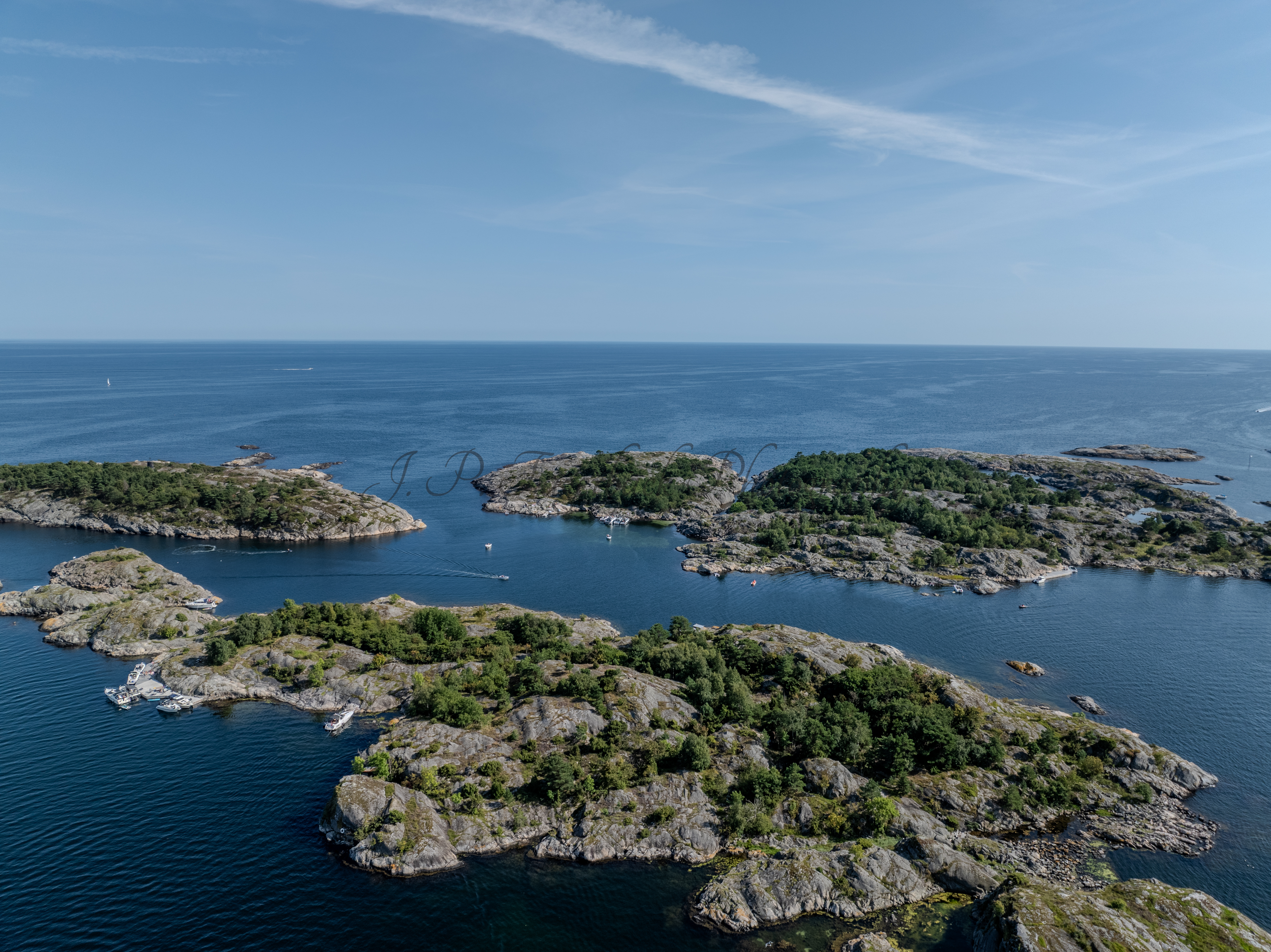 Islands with green vegitaions in sourounded by blue ocean water under a blue sky