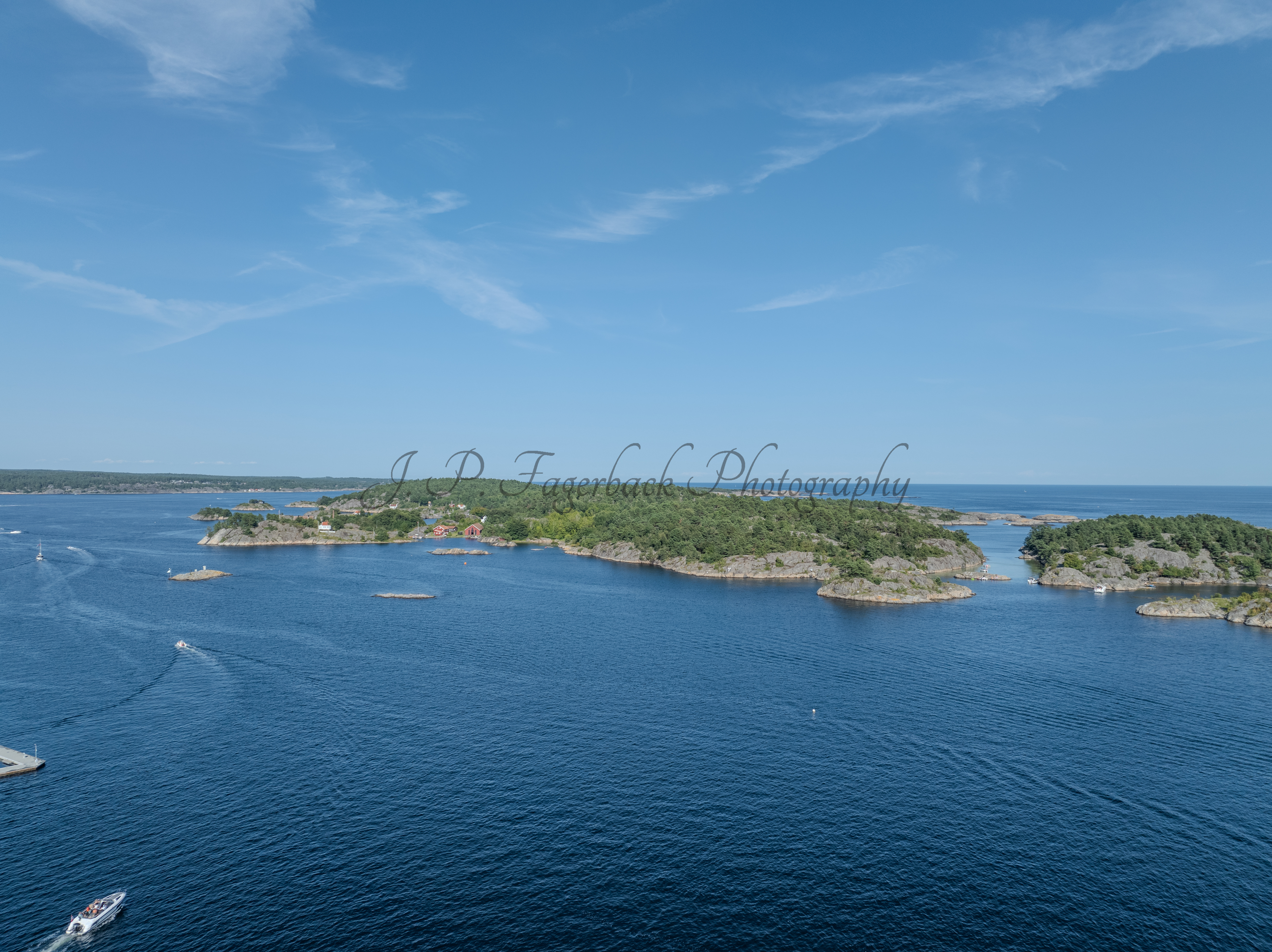 Islands with green vegitaions in sourounded by blue ocean water under a blue sky