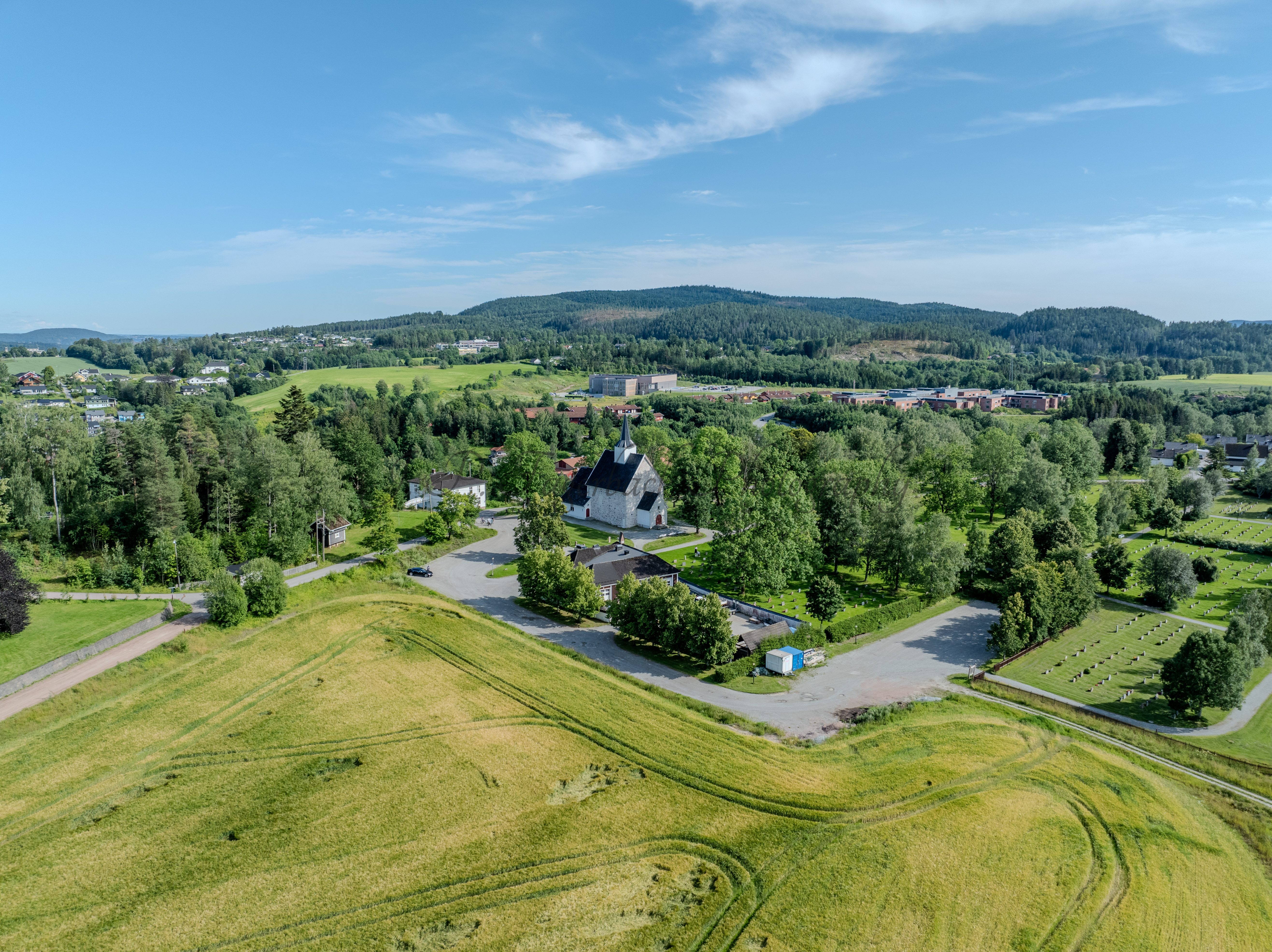 White stone church in a green landscape under a blue sky
