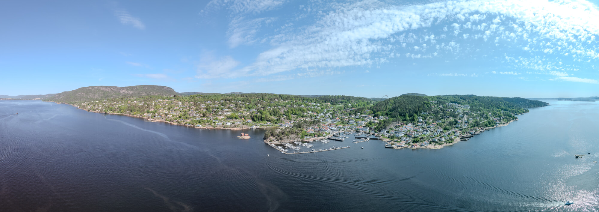 Buildings seen from a body of water with a blue sky