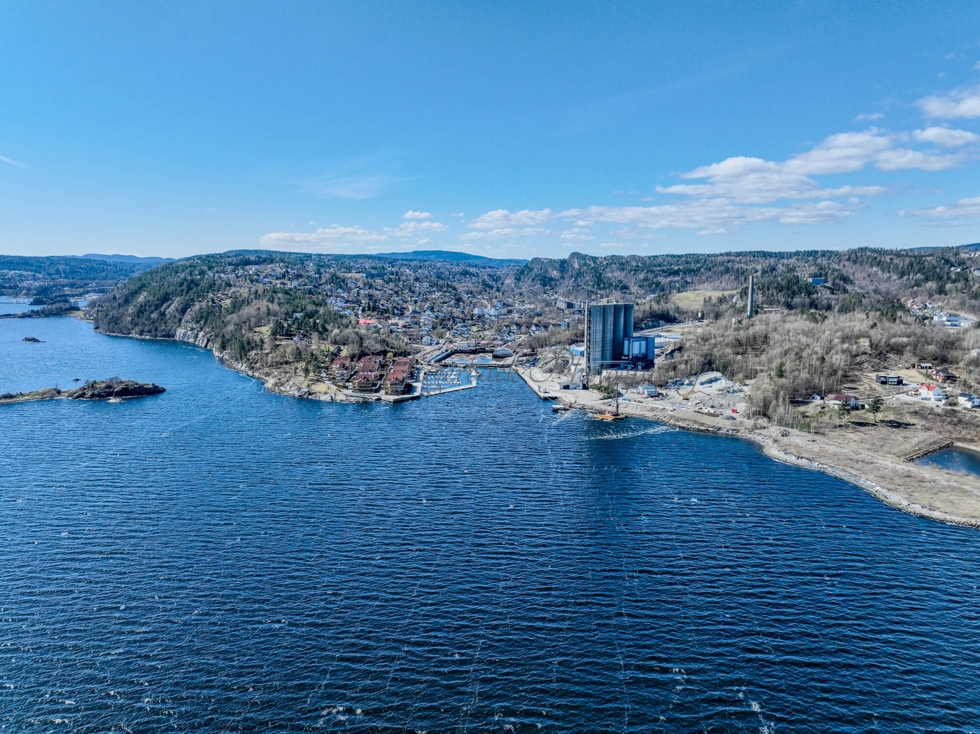 Buildings seen from a body of water with a blue sky