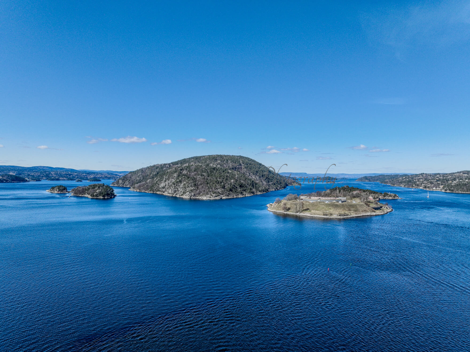 Two islands in a body of water where the right one has a fort on it