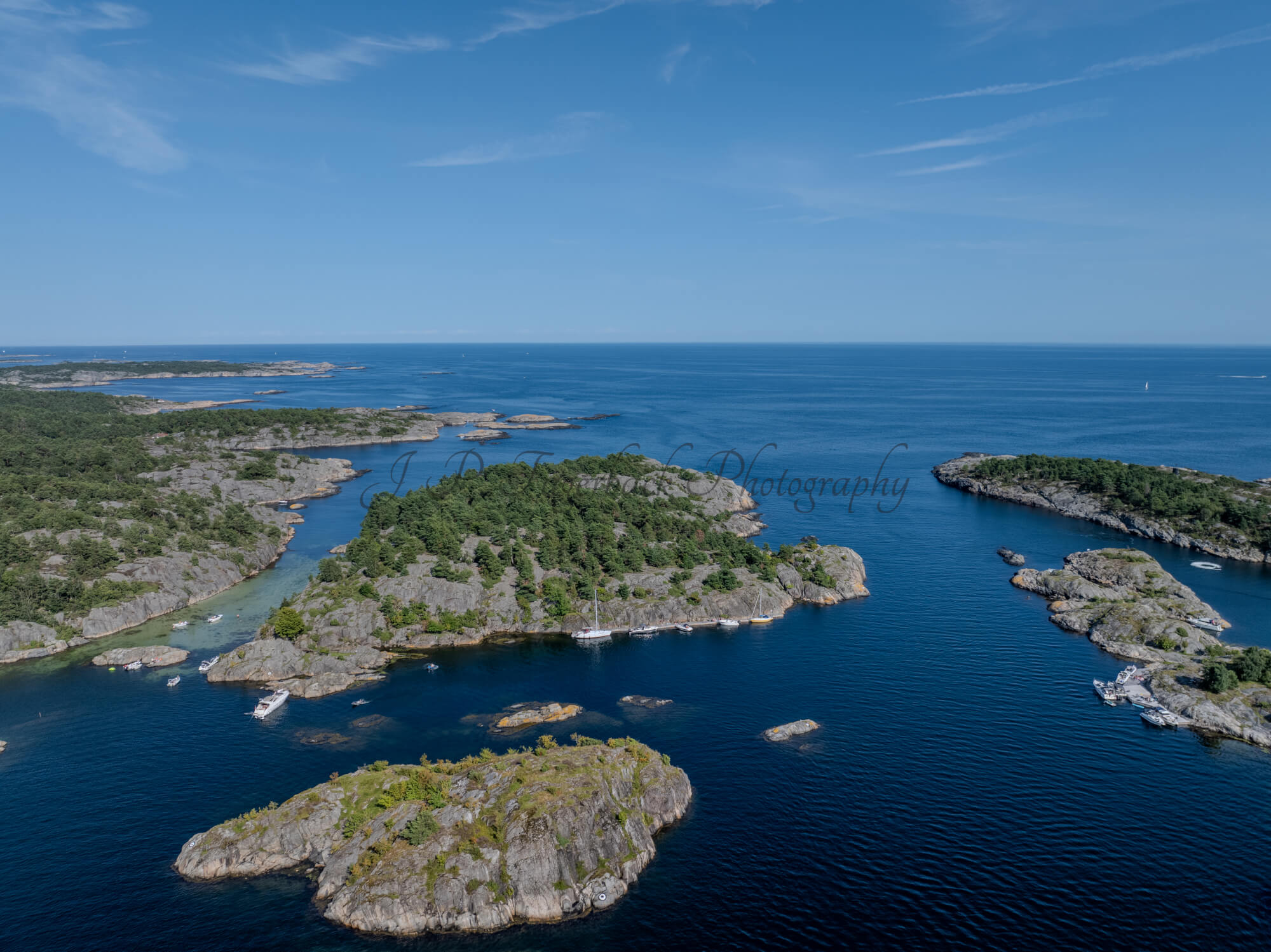Islands with green vegitaions in sourounded by blue ocean water under a blue sky