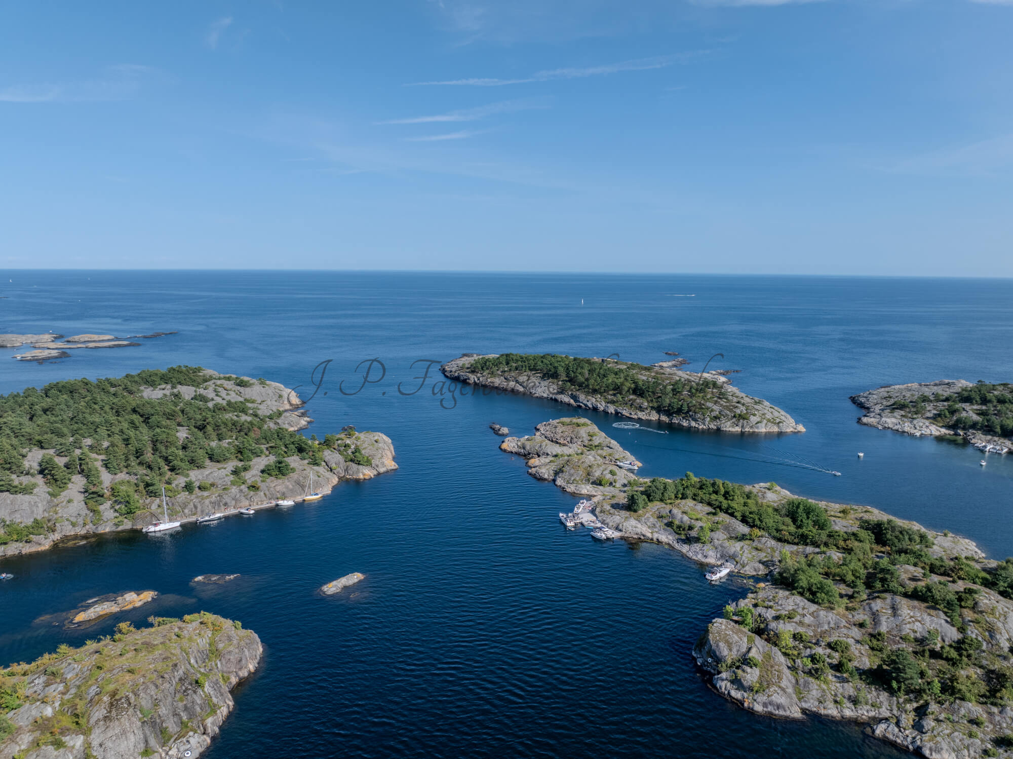 Islands with green vegitaions in sourounded by blue ocean water under a blue sky