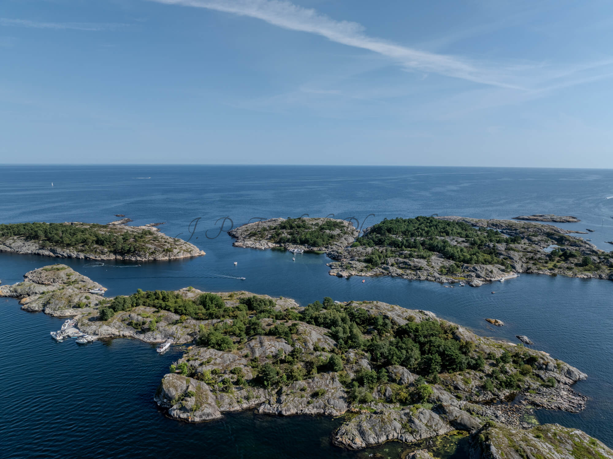 Islands with green vegitaions in sourounded by blue ocean water under a blue sky