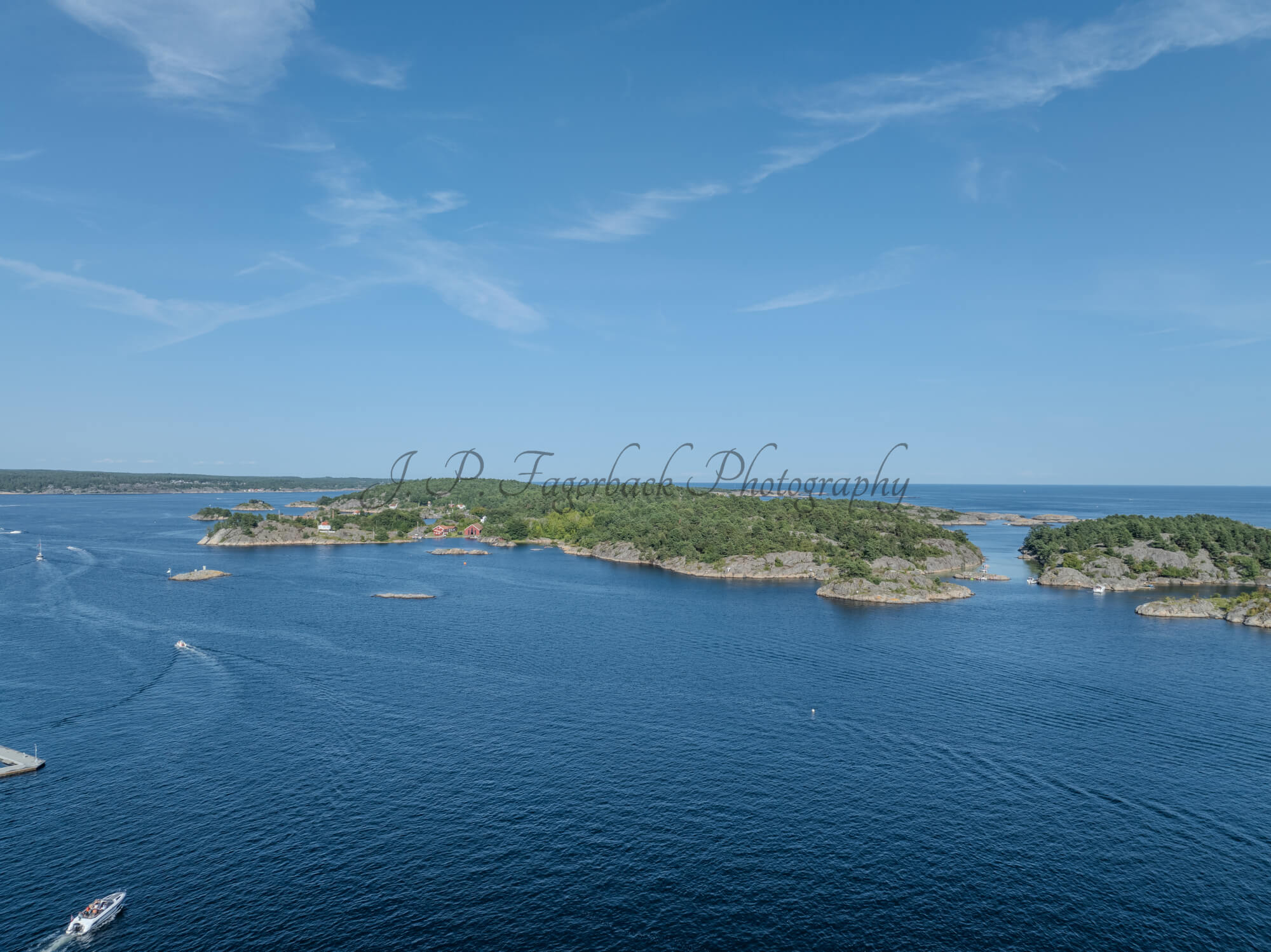 Islands with green vegitaions in sourounded by blue ocean water under a blue sky