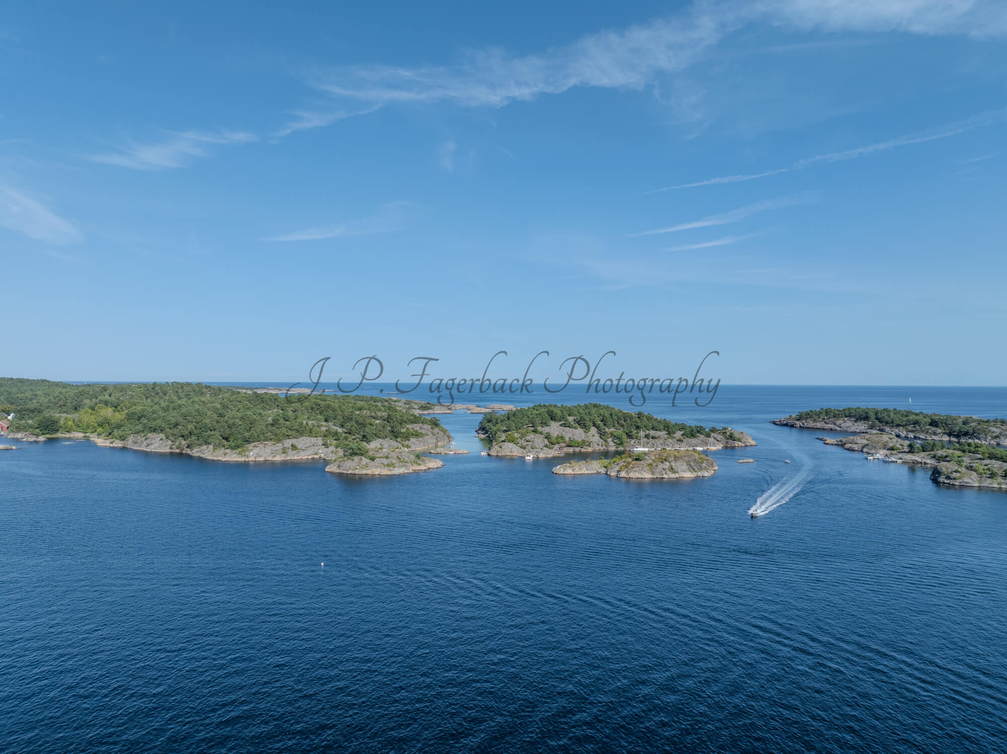Islands with green vegitaions in sourounded by blue ocean water under a blue sky