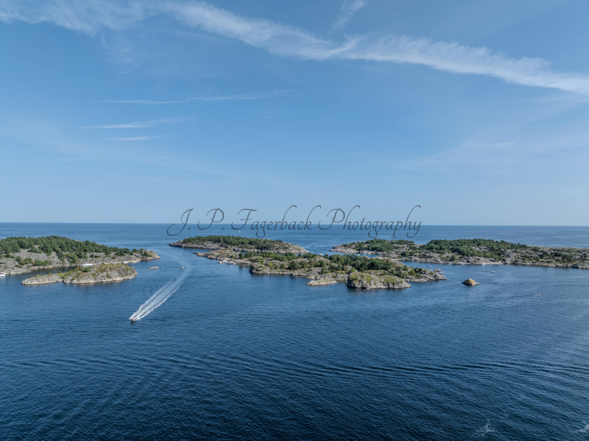 Islands with green vegitaions in sourounded by blue ocean water under a blue sky
