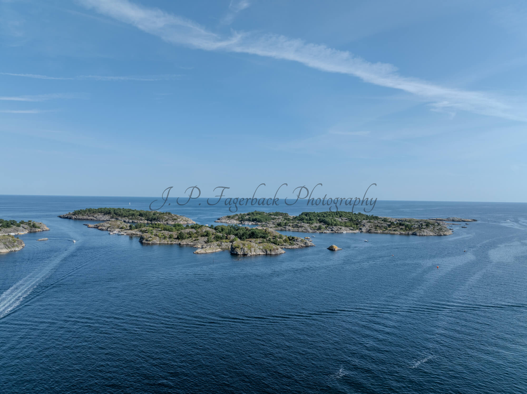 Islands with green vegitaions in sourounded by blue ocean water under a blue sky