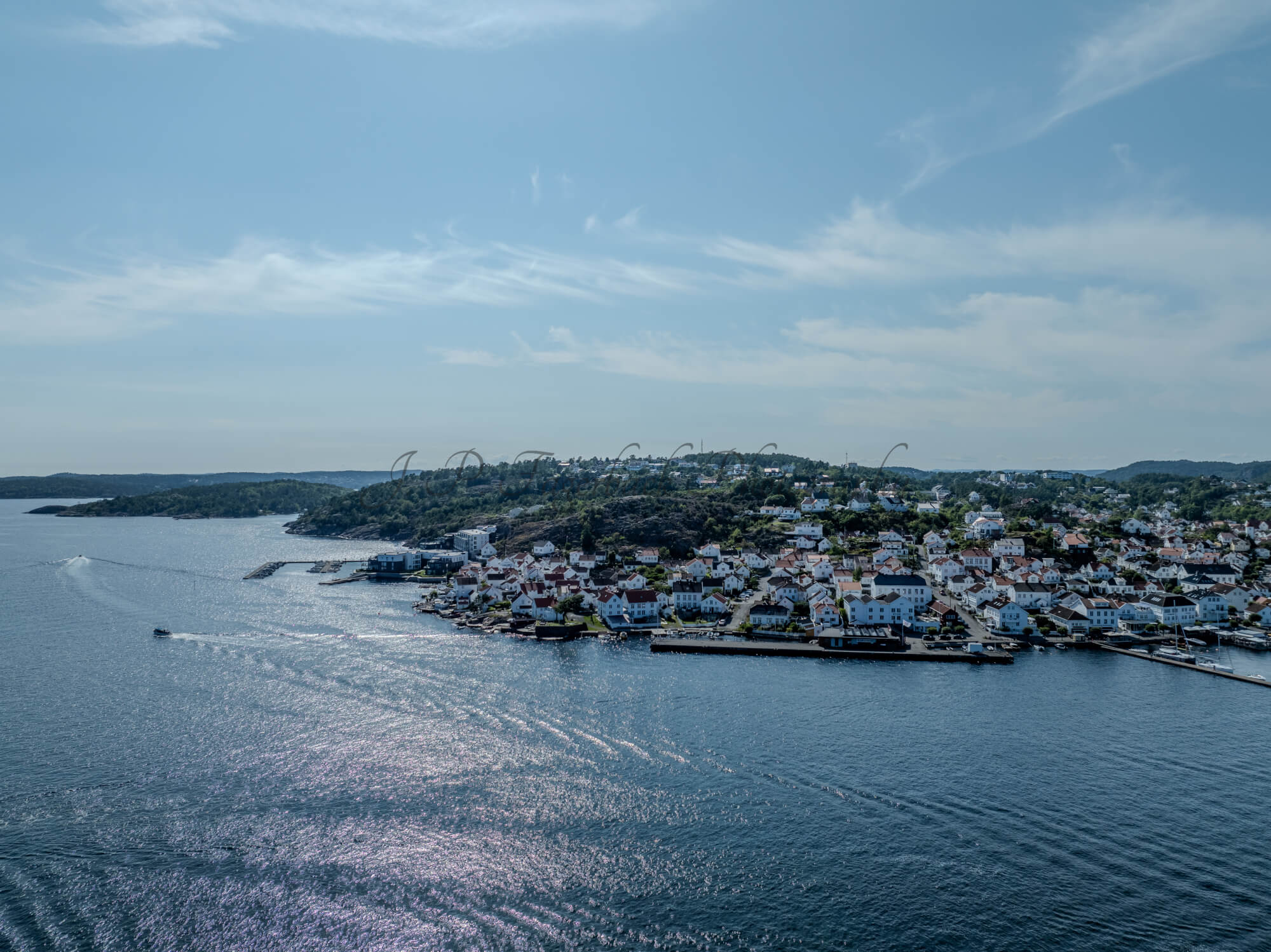 A town with small white houses along a shoreline