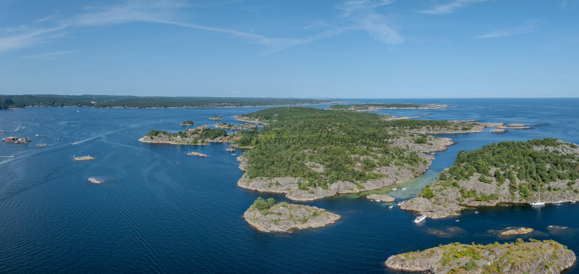 Islands with green vegitaions in sourounded by blue ocean water under a blue sky