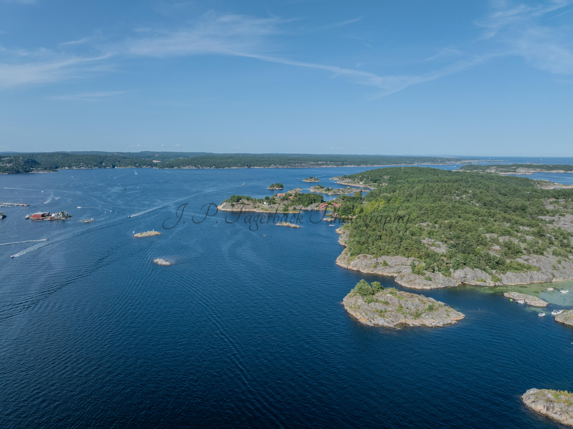 Islands with green vegitaions in sourounded by blue ocean water under a blue sky
