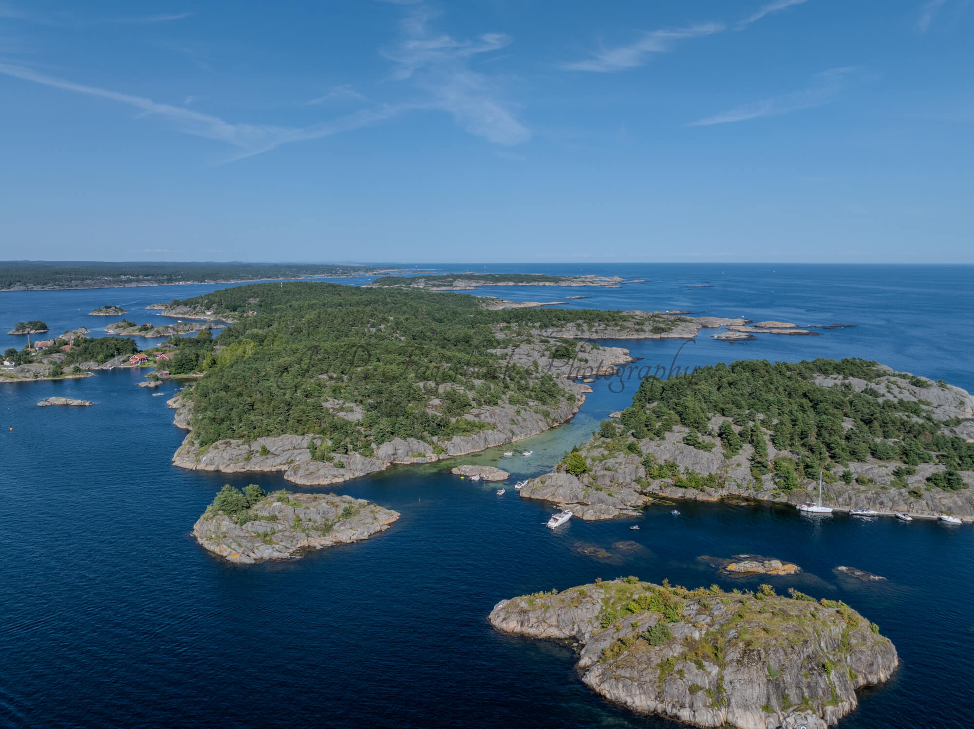 Islands with green vegitaions in sourounded by blue ocean water under a blue sky